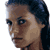 Pixelated static image of a person's face in profile view with dark hair and brown skin tone, rendered at low resolution on white background.