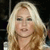 A static pixelated image of a person with long blonde hair, light skin, and a neutral expression against a dark background.