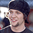 A pixelated image of a person wearing a dark beanie and black shirt with text reading "Bam is awesome!!!" on red background.