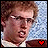 Pixelated image of a person with light brown curly hair and a white collared shirt, featuring two heart symbols at the bottom right corner that change from red to black.