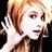Pixelated image of a person with light brown hair, pink eyeshadow, and white clothing against black background.