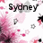 Pixelated image with 'Sydney' text in black, pink and white floral background, scattered gray and black pixel fragments.