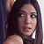 Pixelated close-up of a person with long dark hair, light skin tone, and visible shoulder in dimly lit setting.