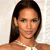Pixelated portrait of a person with long dark hair, light skin, and a neutral expression wearing a white top against a light background.