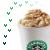A white cup with a green circular logo containing a black-and-white Starbucks siren, topped with light brown whipped cream and drizzled caramel sauce.
