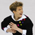 Static pixelated image of a person in formal attire with colorful square accents on the chest, holding an object against a plain background.