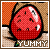 Pixelated red fruit with black seeds and a green stem, set against a checkered background with the word YUMMY below.