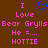 Brown background with pink pixelated text and a blue heart symbol, displaying 'I Love Bear Grylls He =.... HOTTIE' in two identical vertical
