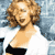 Static pixelated image of a person with curly light brown hair wearing a white top and black shorts against a blue-gray background.