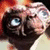 Animated close-up of a character with large blue eyes and textured skin, showing subtle head movement across frames.