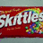 Static image of Skittles candy packaging with rainbow text and a pixelated rainbow graphic.
