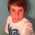 Pixelated image of a person with short brown hair wearing a white shirt featuring dark blue and black graphic design against muted teal background.