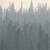 Pixelated cityscape with tall buildings under a light sky, rendered in muted grays and soft pastels.