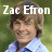 Pixelated image of a person with light brown hair wearing a light blue shirt with dark blue accents, overlaid with white text reading "Zac Efron" against a green background.