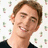 Pixelated portrait of a smiling person with brown hair on left, bright pink background with text and heart symbols.