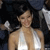 A pixelated image shows a person with light skin wearing a white sleeveless top against a dark background with light-colored shapes.