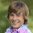 A young person with light brown hair and a light blue shirt smiles against a green background, with pink text overlays changing across frames.