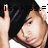 A static pixelated image shows a person with dark hair making a peace sign gesture, wearing light-colored clothing against a black background.