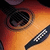 A pixelated close-up of a character's eye with an orange and red gradient background, featuring a checkered pattern on the lower right.