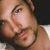 Pixelated close-up of a person's face with visible facial features and partial body, displayed as a static buddy icon.