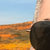 A static image shows a landscape with a gradient sky transitioning from light blue to orange, a dark silhouette on the right, and a textured ground area in warm tones.