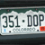 Static image of a license plate with dark green text on a white background, featuring the number '351' and letters 'DOP' separated by a dot, with partial text 'colorado' below.
