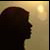 Silhouette of a person's head and shoulder in profile against a gradient background with a bright light source on the right.