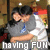 Two pixelated figures embrace in a dimly lit indoor setting with visible text reading 'HAVING FUN' at the bottom.