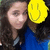 A person with long dark hair wearing a blue top, partially obscured by a yellow smiley face icon in the upper right corner.