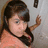 A pixelated image of a person with dark hair in an orange top, reaching toward a wall-mounted object; text reads "Elvia Rockz Chur Sockz!! =]".
