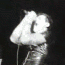 Black-and-white animated sequence showing a musician playing guitar and singing into a microphone, with dynamic motion