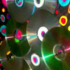 A static digital image featuring overlapping translucent circles with glowing borders in cyan, yellow, red, and white, set against a dark background with green and blue light streaks.