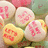 Pixelated image of four round objects with pink and red patterns on light backgrounds, set against a blurred greenish-brown backdrop.
