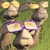 Pixelated image of a cow with yellow ears and purple glasses against a green background.