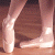 Static image of a person's lower legs and feet in ballet shoes on wooden floor, with green background text reading 'Original Icons .com'.