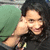 Pixelated static image of a person with dark hair holding hand near face, wearing black shirt against green and dark background.