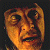 A 50x50 pixel animated buddy icon split into two frames showing a character's face on the left and green text on a dark background on the right, with visible pixelation and dithering effects.