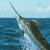 Pixelated static image of a narwhal breaching ocean surface with long tusk extending upward against light blue sky background.