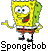 Pixelated yellow cartoon character with green accents, brown shorts, white shirt, red tie, and black shoes standing against a white background.