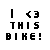 Pixelated image showing a red motorcycle with rider on light gray background, left side displays 'I <3 THIS BIKE!' text.