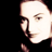 Pixelated close-up of a person's face with visible facial features and partial hair against black background, rendered in low-resolution style typical of early 2000s digital icons.