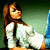 Animated pixel art of a woman in white clothing with brown hair, showing subtle head and body movement against a green background.