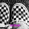 Black-and-white checkered slip-on shoes with visible wear on the toe and sole, partially obscured by a light-colored fabric, with pink text overlay.