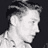 Static grayscale pixel art of a person's head and shoulders in profile view with visible hair, facial features, and neck against dark background.
