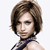 Pixelated portrait of a person with short brown hair, wearing a dark sleeveless top and silver earrings, facing slightly left against a white background.