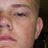 Pixelated close-up of a person's face showing eyes, nose, mouth, and ear with light skin tone against dark background.