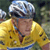 A person wearing a silver helmet and yellow jacket with blue accents, standing against a blurred background.