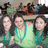 Three figures with long dark hair wear teal and light green tops against a blurred background with indistinct shapes.