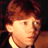 Pixelated static image of a character's face with reddish-brown hair and light skin tone against dark background.