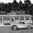 Black-and-white animated sequence showing a diner building with parked cars, text overlays changing across frames.